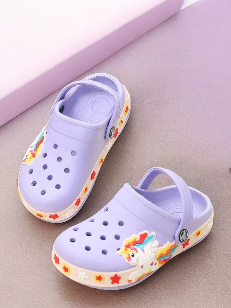 Purple children's clogs adorned with vibrant unicorn and rainbow accents on a purple background.