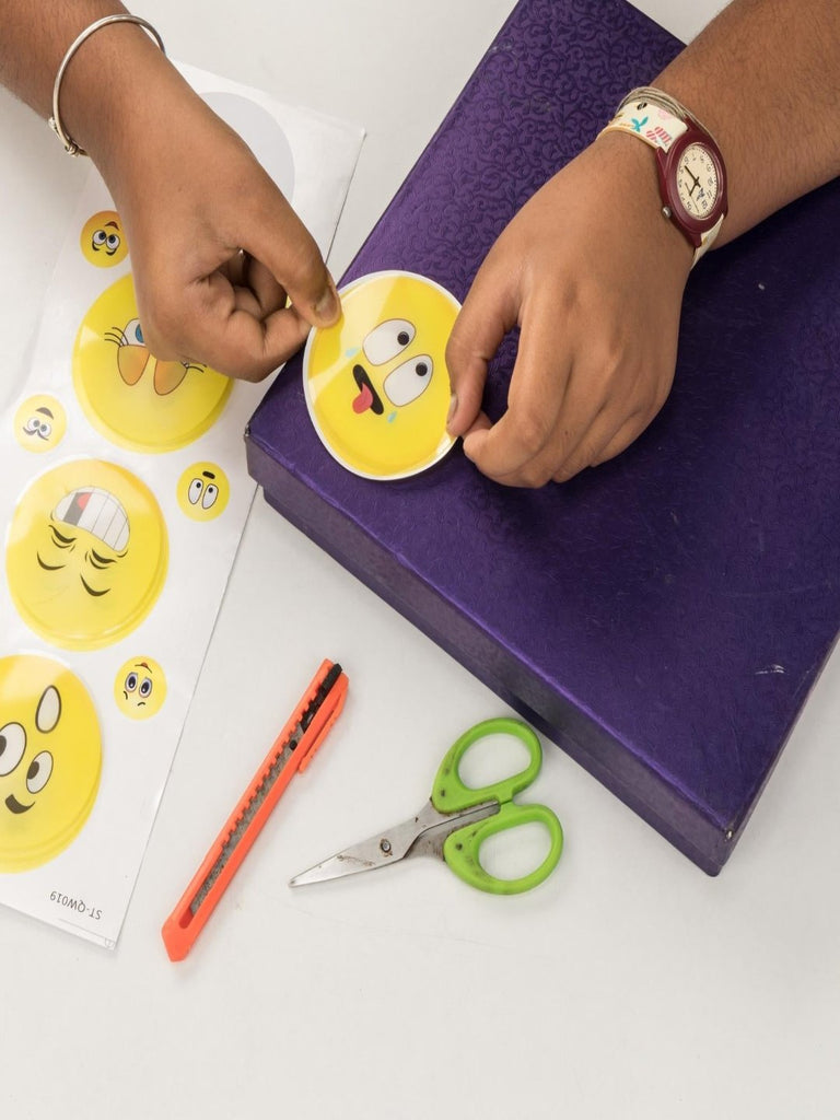 Close-up of Yellow Bee smiley stickers being applied, highlighting their easy peel-and-stick design.