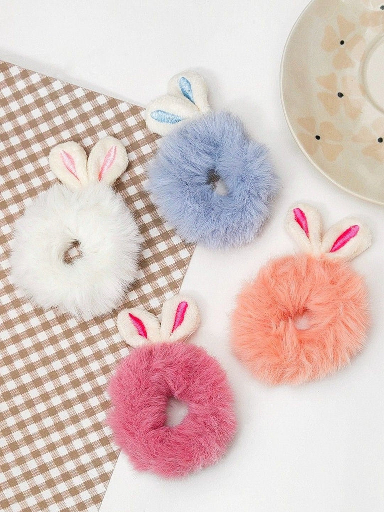 A charming set of four Yellow Bee fur scrunchies with cute bunny ears, displayed on a plaid background, perfect for accessorizing young girls' hair.