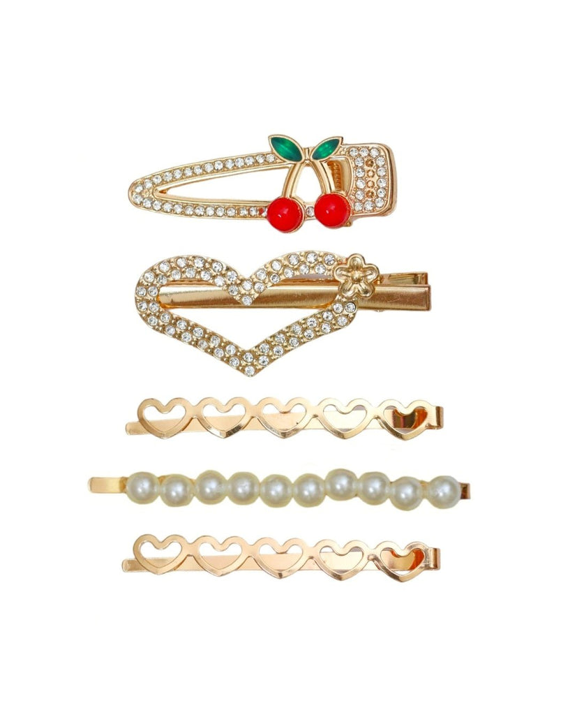 A top-down view of Yellow Bee's hair clip set, featuring a golden rhinestone heart, pearl-embellished clips, and a whimsical cherry design