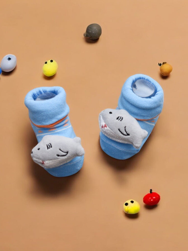 A creative-up view of the plush shark detail on the baby socks.