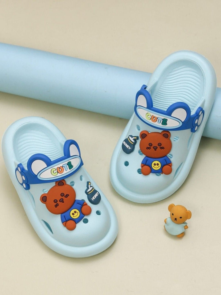 A creative presentation of sky blue clogs with a bear theme, set against a playful background.