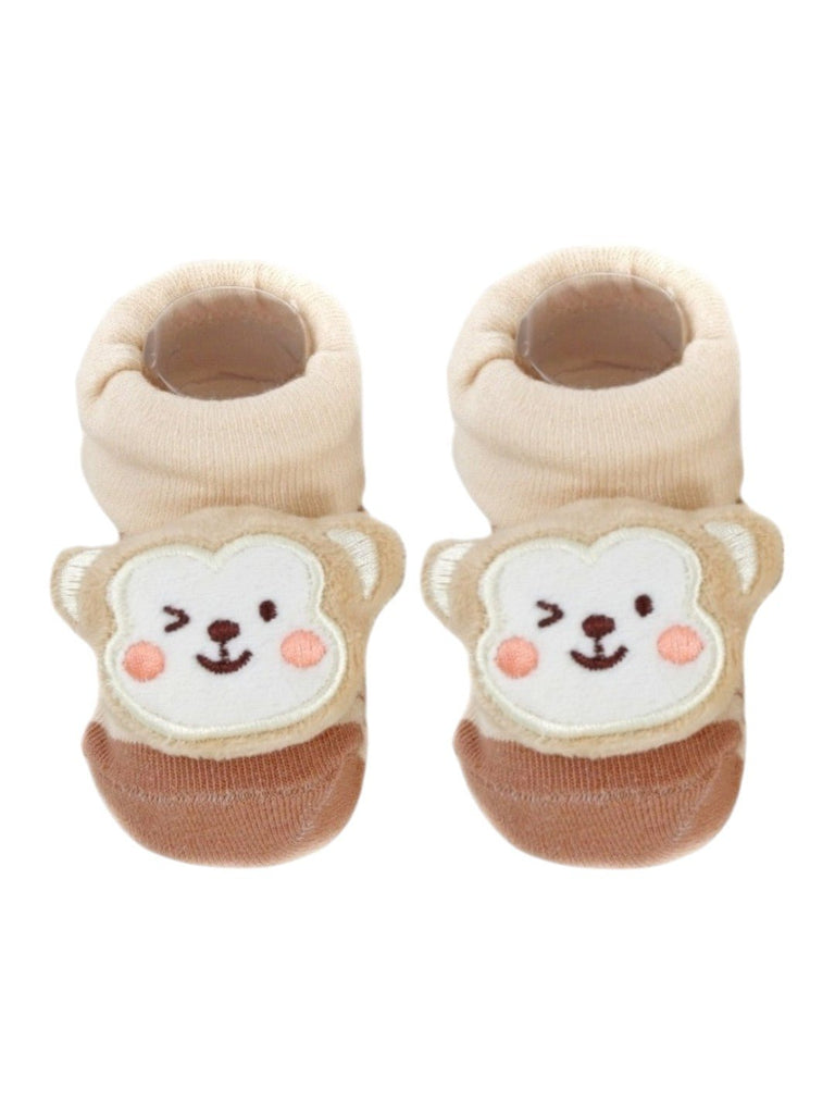 Top view of beige baby booties showcasing a playful 3D monkey face, perfect for baby boys and girls.