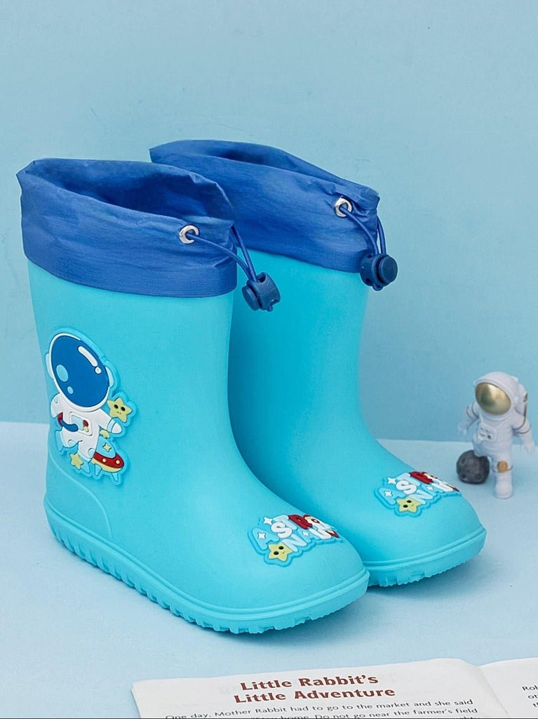 Display of Blue astronaut themed rain boots for boys in a creative setting with space-themed props.