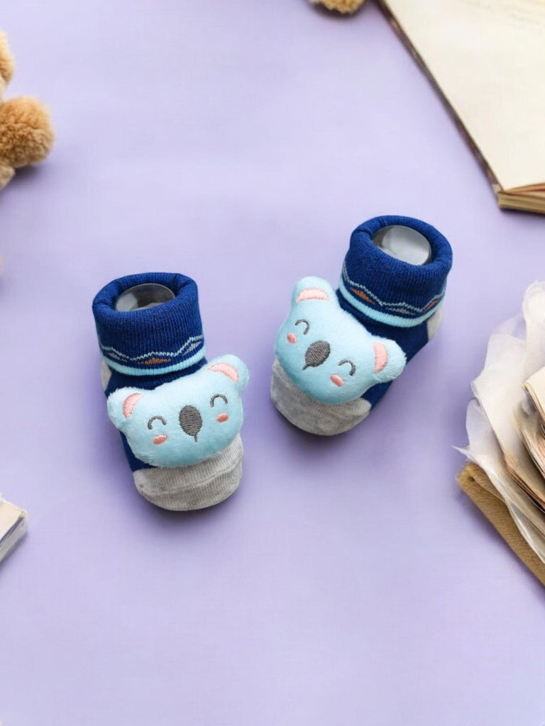 Creative display of blue baby booties featuring a cute 3D koala, designed to add comfort and charm to any baby’s wardrobe.