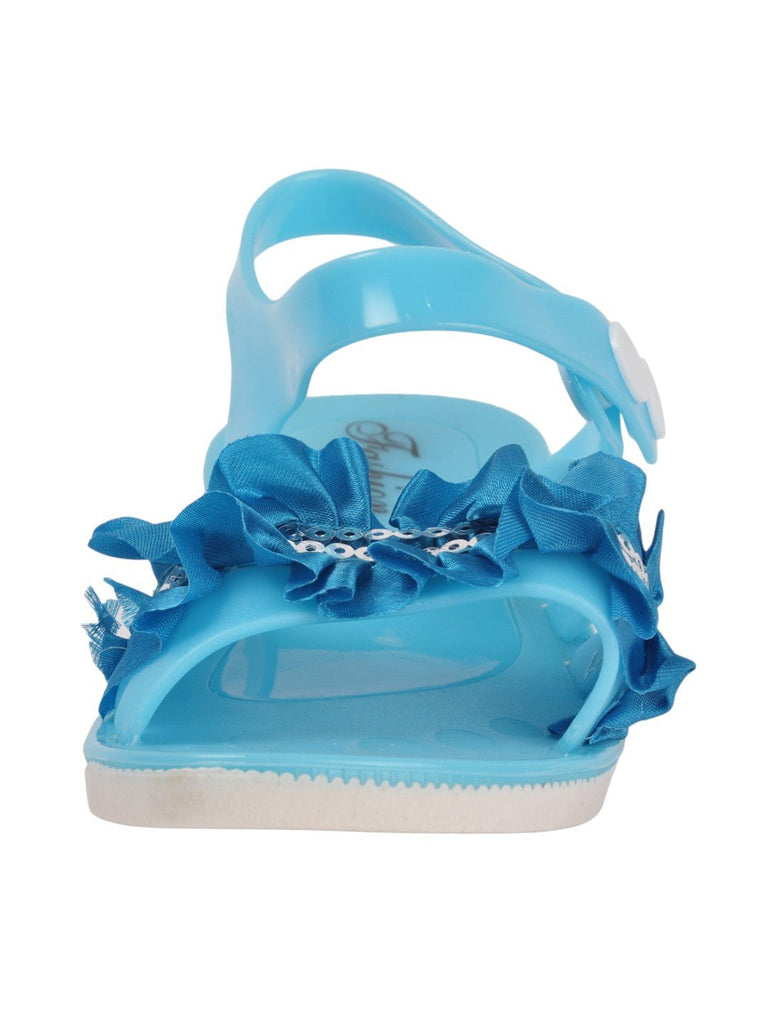 zoom view of blue sandals featuring a ruffled bow and sequin accents.