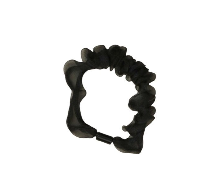 Close-up of the black scrunchie, emphasizing the fabric's texture and sheen