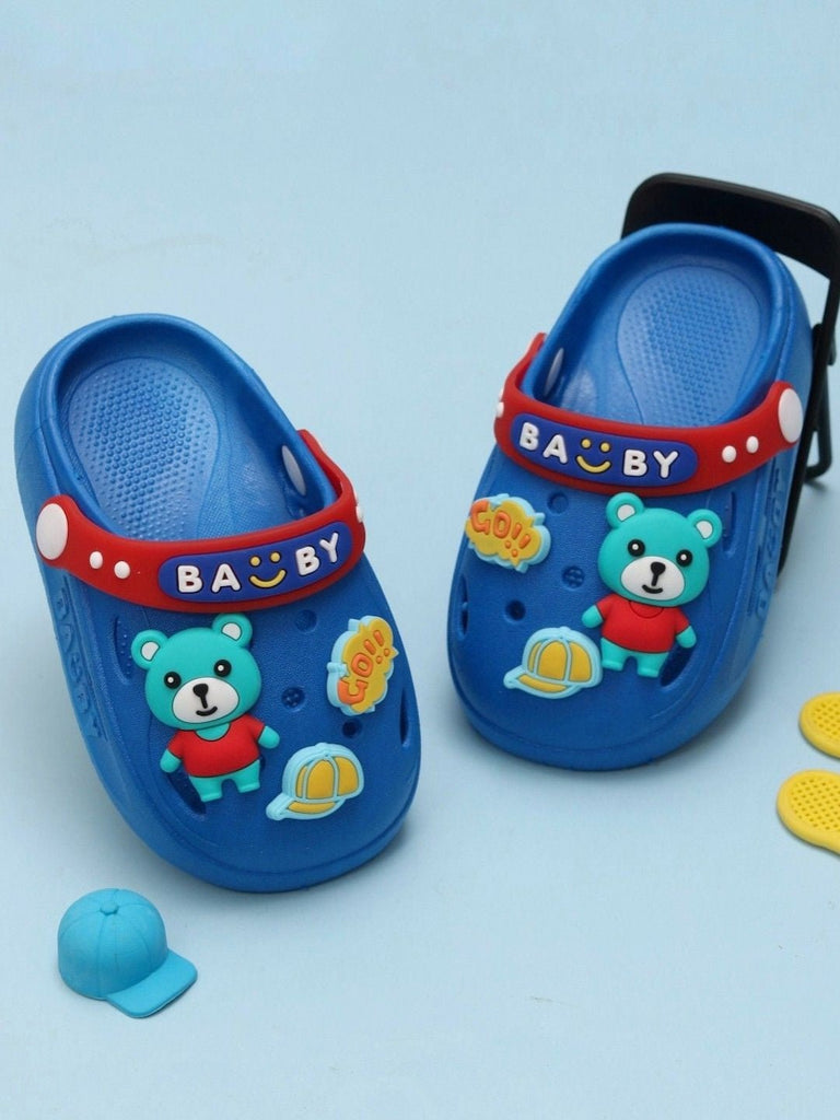 Creative display of Yellow Bee Boy's Blue Teddy Bear Adventure Clogs alongside playful accessories.