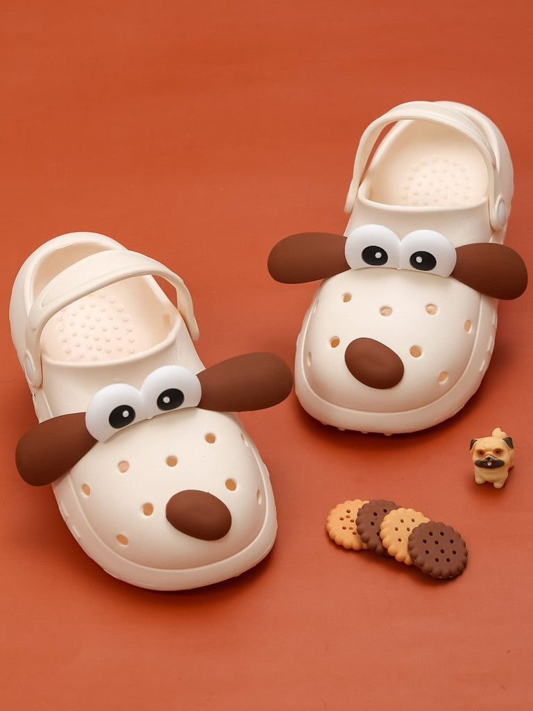 Playful display of Yellow Bee Children's Puppy-Themed clogs with toy and cookies.