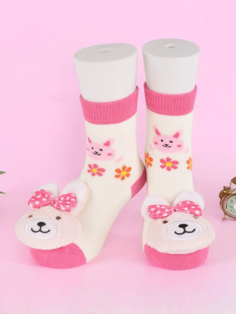 Infants' bunny stuffed toy socks in white and pink with a playful bow. creative view