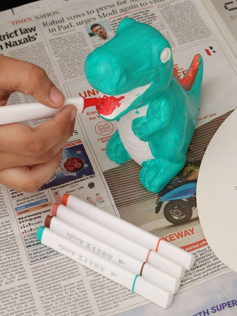 Child coloring the Yellow Bee Colourme Ceramics DIY Dino Model with acrylic markers.