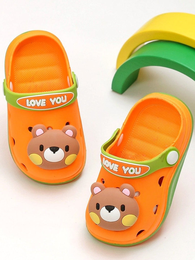 Creative presentation of the teddy bear-themed orange clogs in a playful environment.