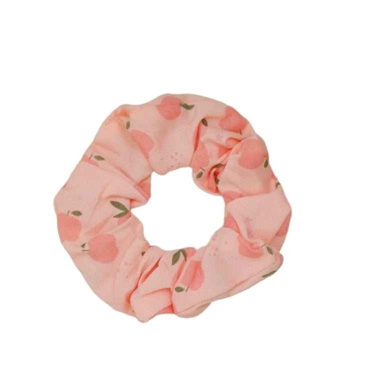 Close-up of Yellow Bee's peach scrunchie with delicate floral patterns.