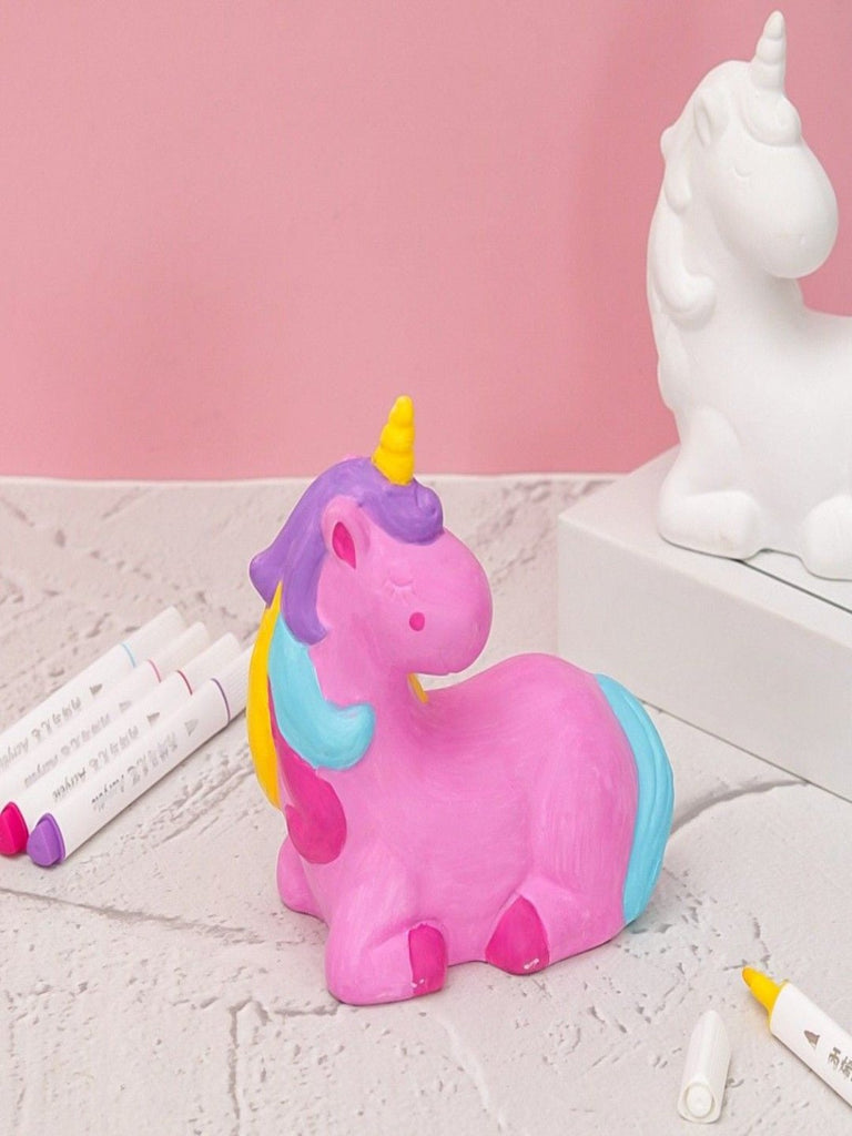  Child coloring a ceramic unicorn with bright acrylic markers from the Yellow Bee DIY kit.