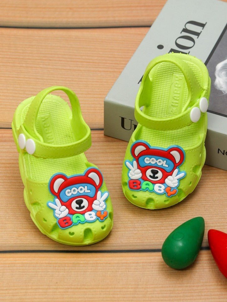 Pair of Cool Baby Bear Sandals in green displayed on a wooden surface
