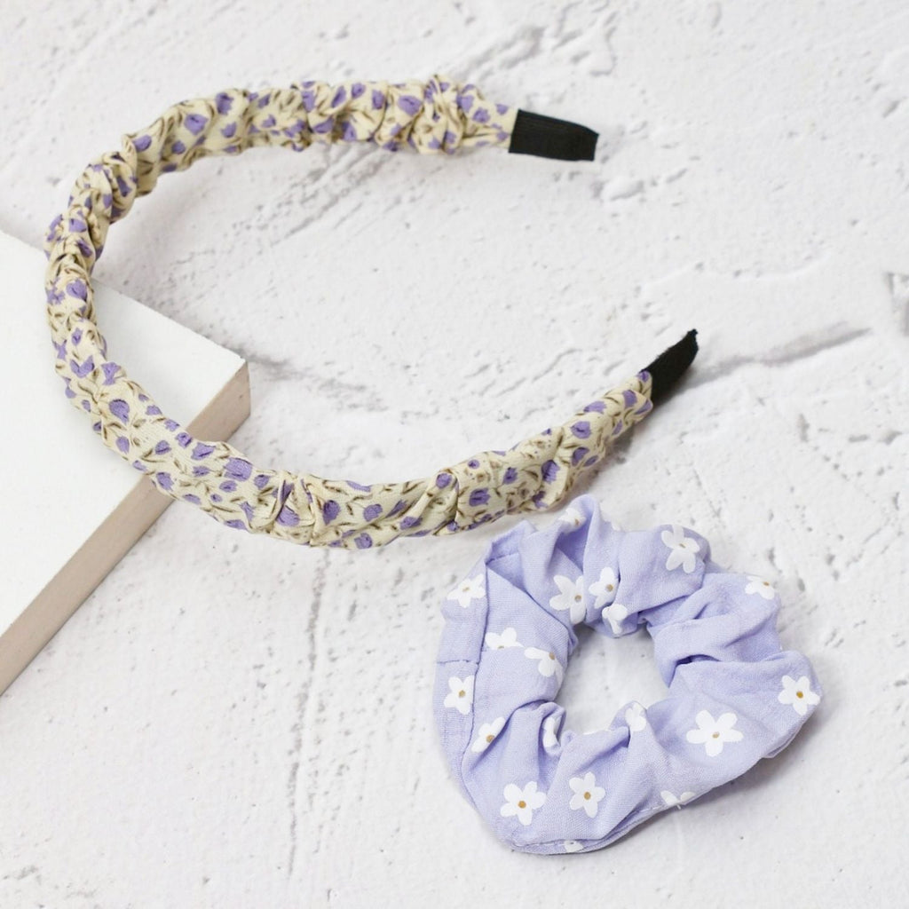 Yellow Bee's yellow and purple floral hairband and daisy scrunchie displayed in a lifestyle setting, illustrating the product's charm.