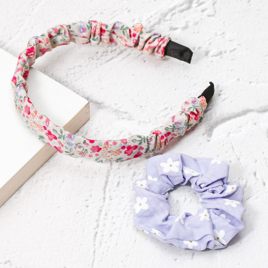 Yellow Bee's pink and purple floral hairband and daisy scrunchie set, displayed with a stylish background for lifestyle appeal.