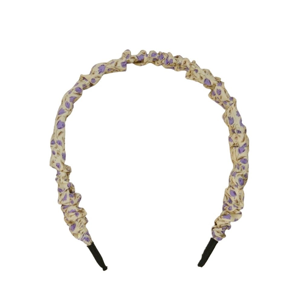 Close-up of Yellow Bee's crinkled yellow  and purple floral hairband highlighting the fabric's texture.