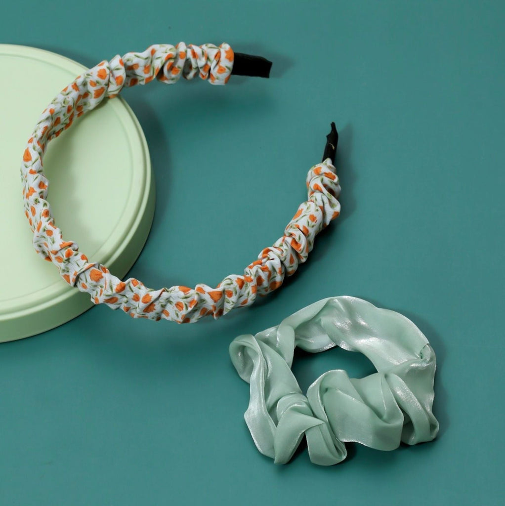 The Yellow Bee orange and green hairband and scrunchie combo presented in a lifestyle setting, emphasizing the playful design.