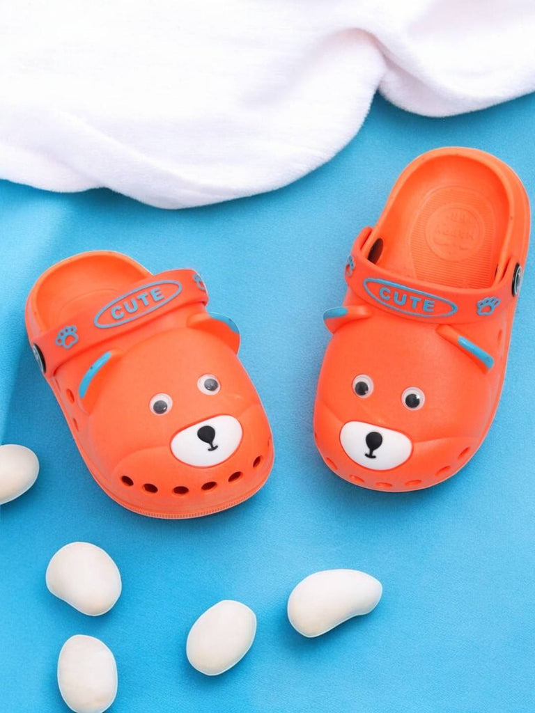 Orange kids' clogs with a playful bear face design and secure strap..