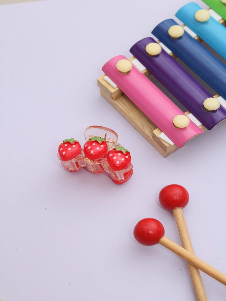 A creative view of the Cute Triple Strawberry Hair Claw Clip in red, featuring three adorable strawberries on a transparent acrylic base.