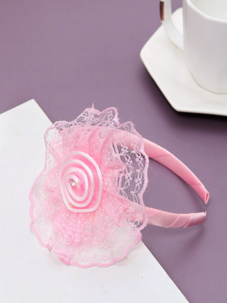 Creative view of the delicate baby hairband in pink with lace flower and satin ribbon detailing.