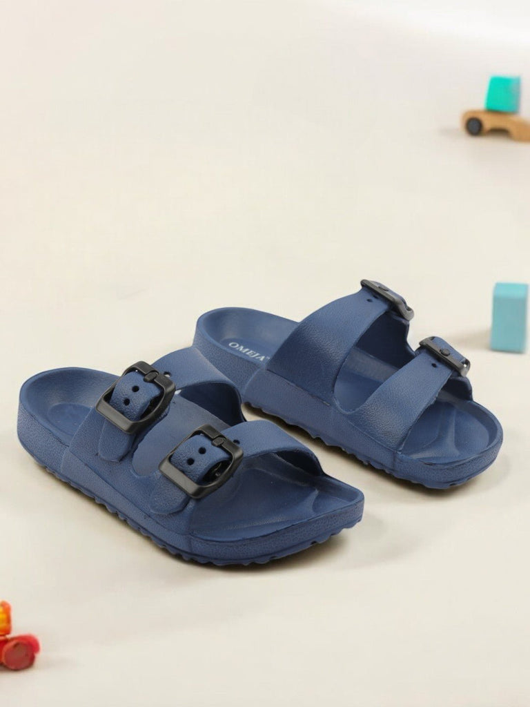 Creative view of Double Buckle Slides for Boys in Navy Blue placed on a wooden background.