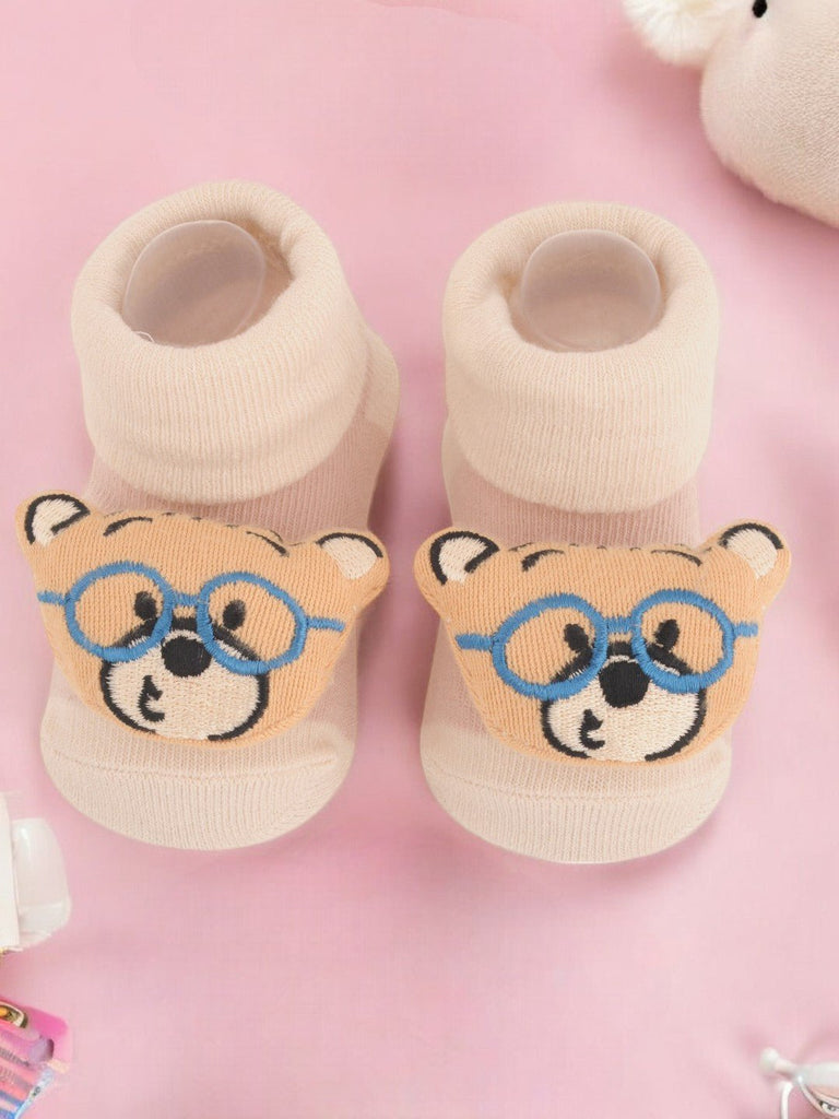 Pair of beige teddy bear socks with blue glasses design for children creative view