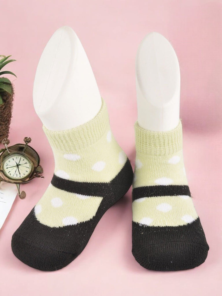 Creative view of baby’s black and yellow polka dot socks with faux shoe design by Yellow Bee.