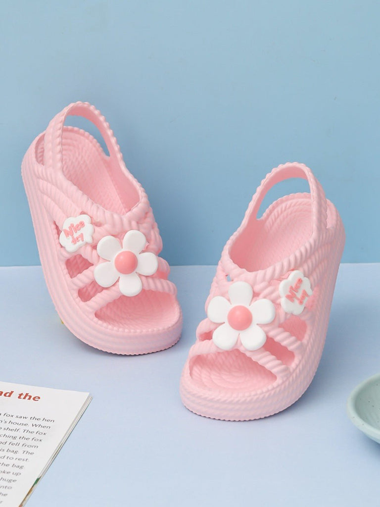 Creative setting showcasing Yellow Bee's Pink Children's Sandals with white floral applique, a blend of comfort and cute style.