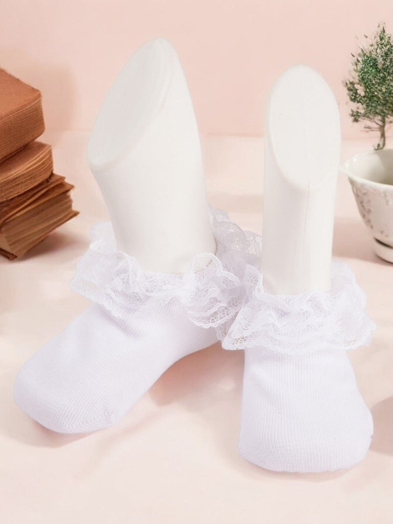 Side view of white lace frill socks with ruffle detail on a display foot creative view