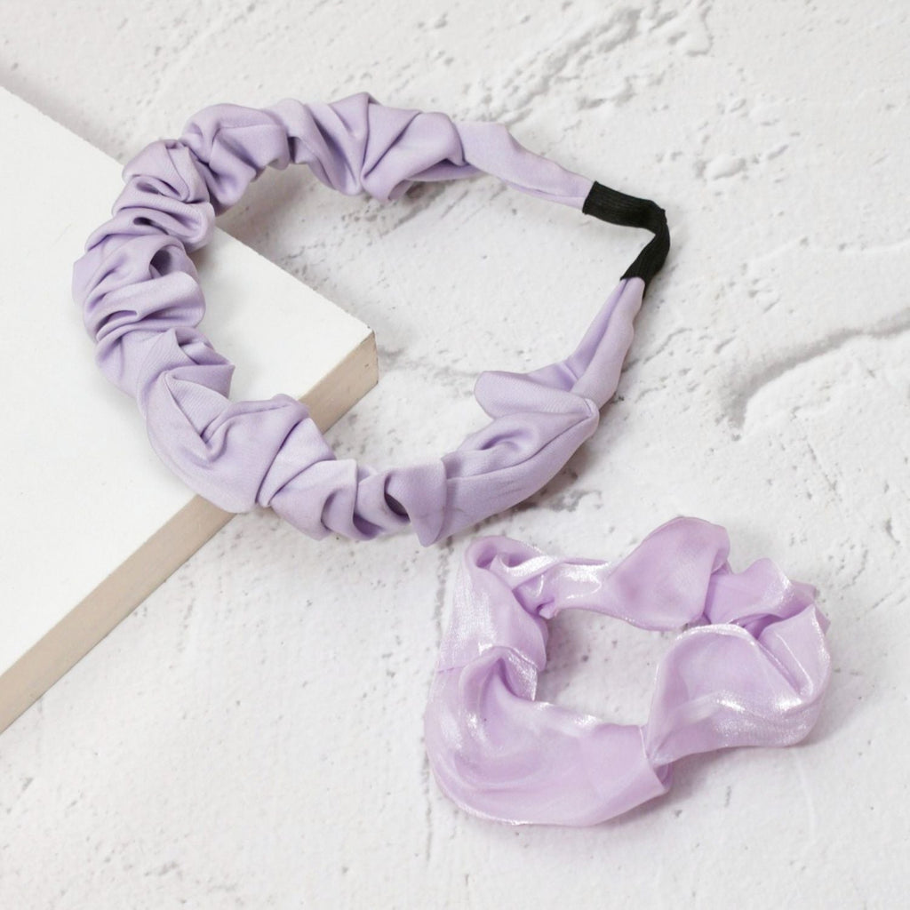 Yellow Bee's purple hairband and scrunchie set laid out elegantly, ready to complement any hairstyle.