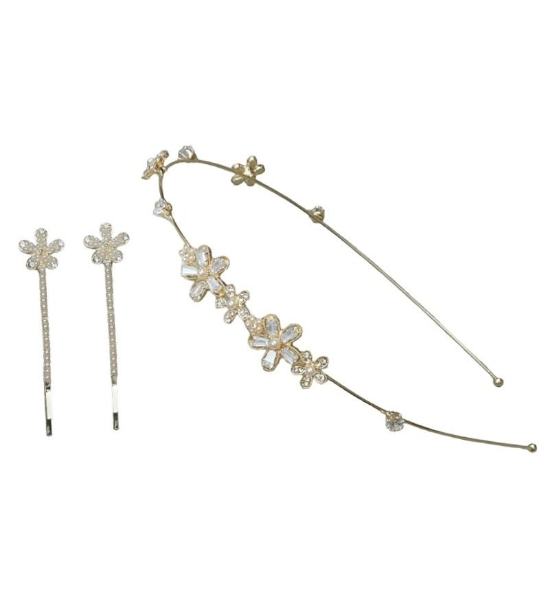 A set of Yellow Bee hair accessories featuring a golden hairband and two hair clips with faux pearl flowers, presented on a white background.