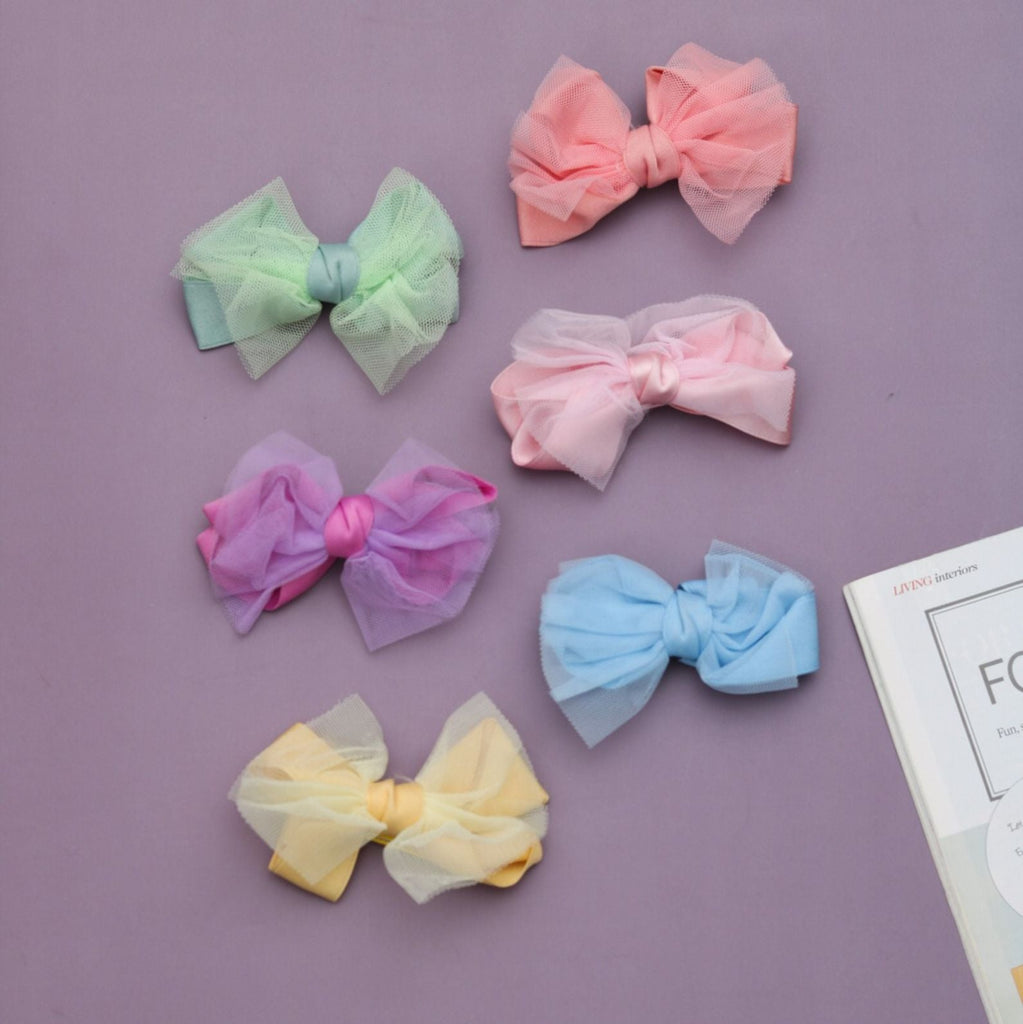 Assorted collection of Yellow Bee's bow alligator hair clips in various pastel shades on display.