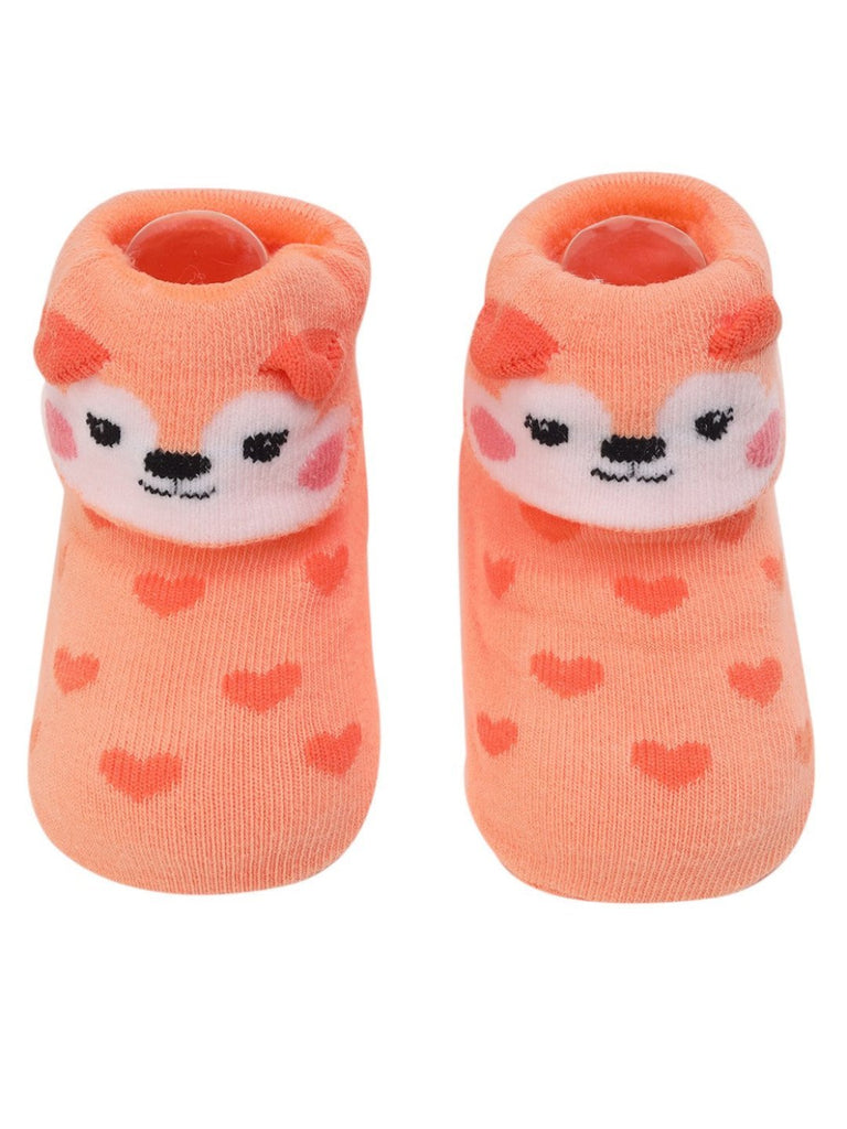 Top view of orange baby booties with 3D puppy face and heart pattern.