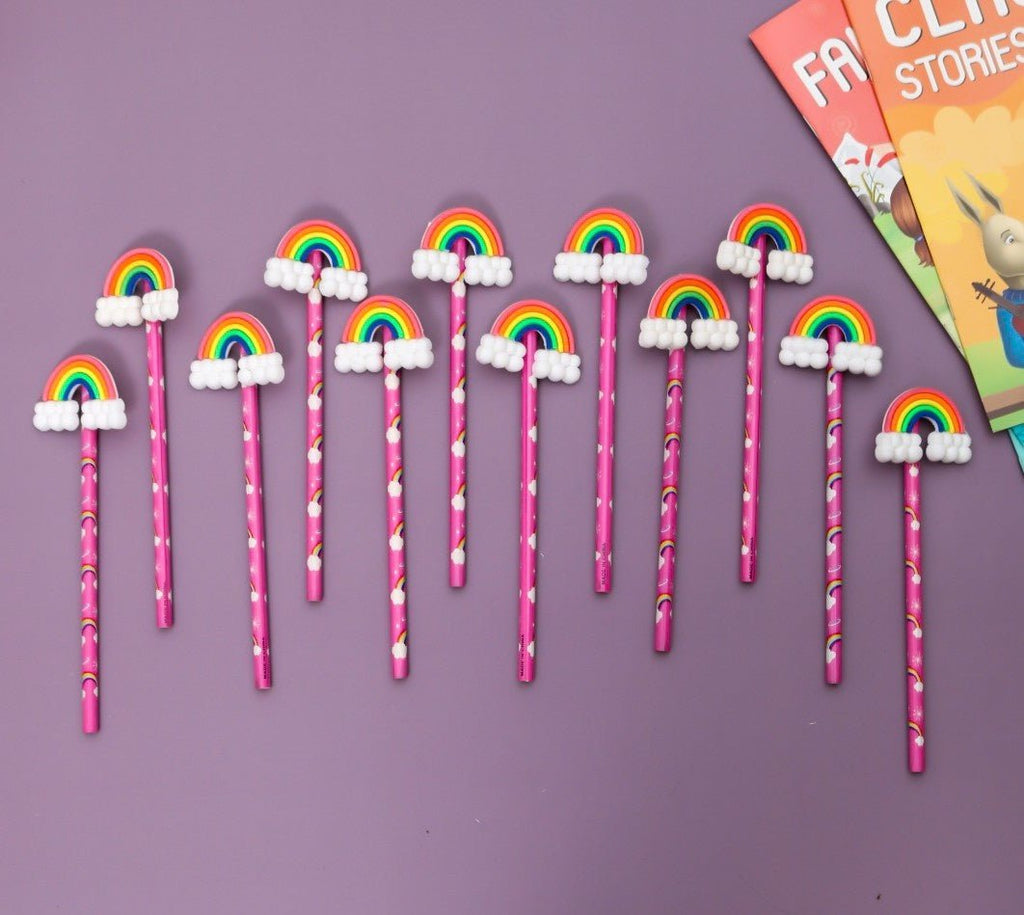 Overhead view of Yellow Bee's pack of 12 rainbow motif pencils, perfect for girls, displayed with a children's book.