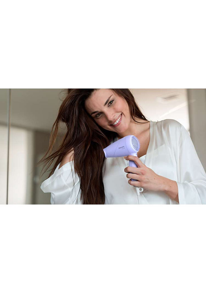 Model drying her hair with Philips 1000 Watts Hair Dryer in a home setting