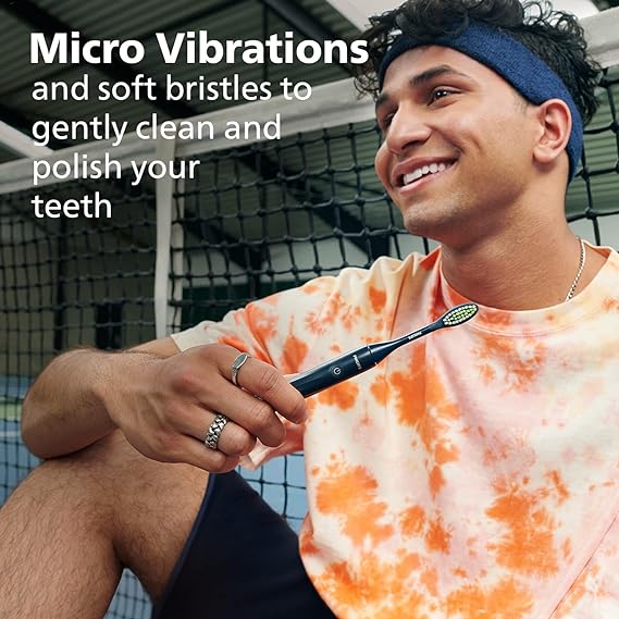 A detailed image showing the features of the Philips One by Sonicare electric toothbrush in navy blue, including micro vibrations and a sleek design.