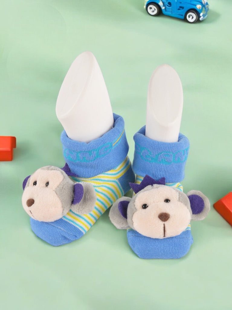 Creative display of baby’s blue socks with a monkey plush detail and colorful striped pattern.