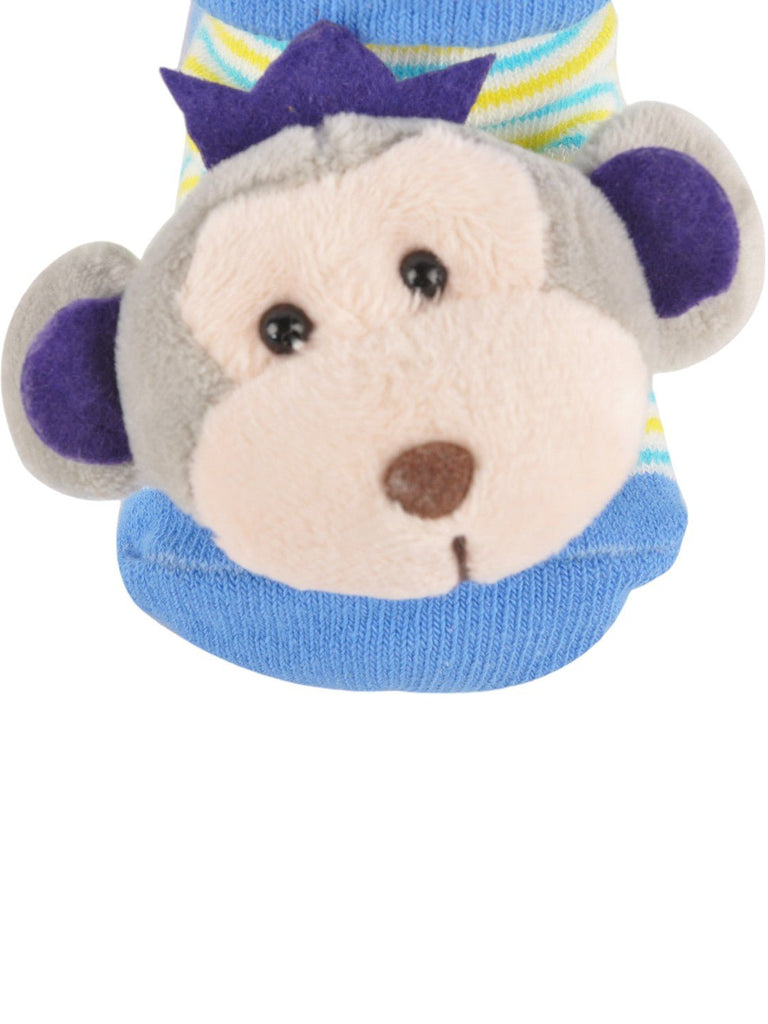 Closeup view of baby’s playful blue socks featuring a cute monkey plush design on the front.