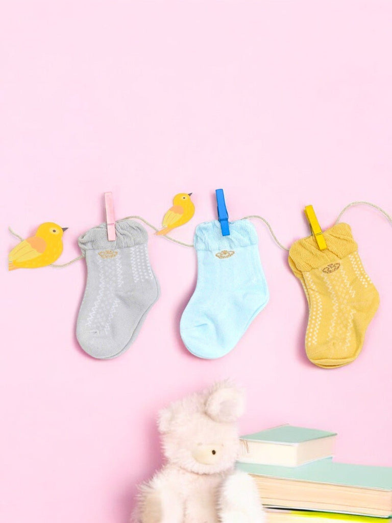 Pastel-colored baby girl socks with crown accents creative view