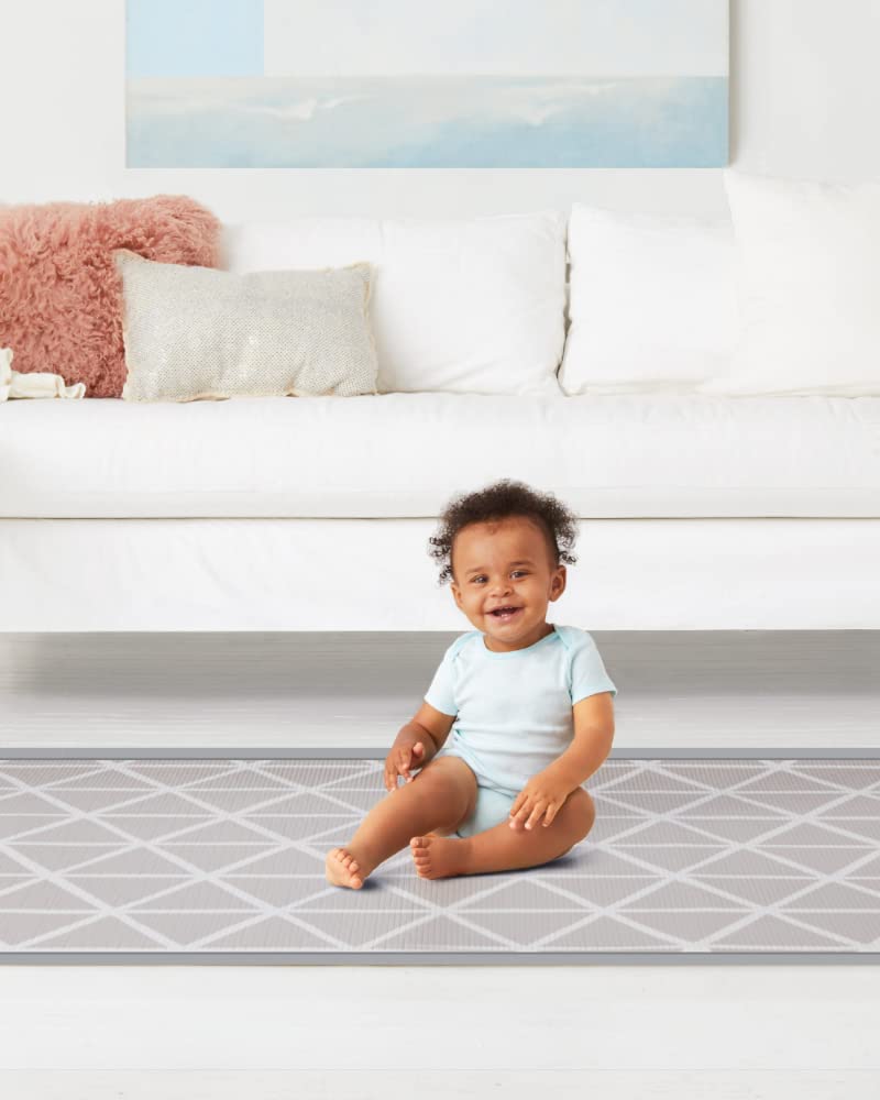  Image showing a child playing on the Skip Hop Doubleplay Reversible Playmat, highlighting the spacious and comfortable play area.