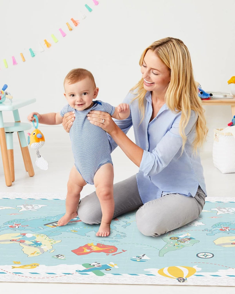 Baby standing on the Skip Hop Playspot Geo Playmat, illustrating the mat's durability and safe surface.