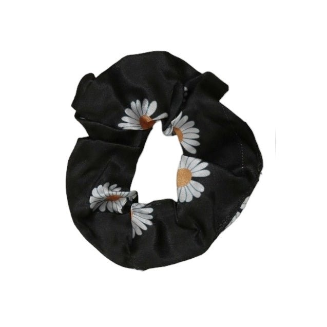 Close-up of Yellow Bee's black daisy scrunchie, emphasizing the floral detail.