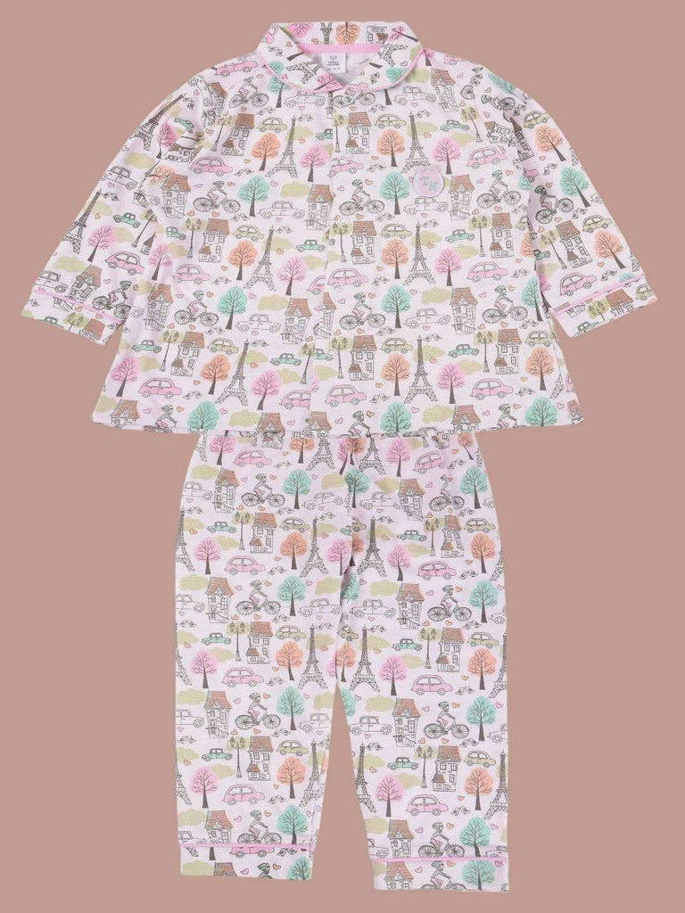 Full view of a girls' pajama set with printed design featuring Parisian landmarks, trees, bicycles, and cars in pastel colors.