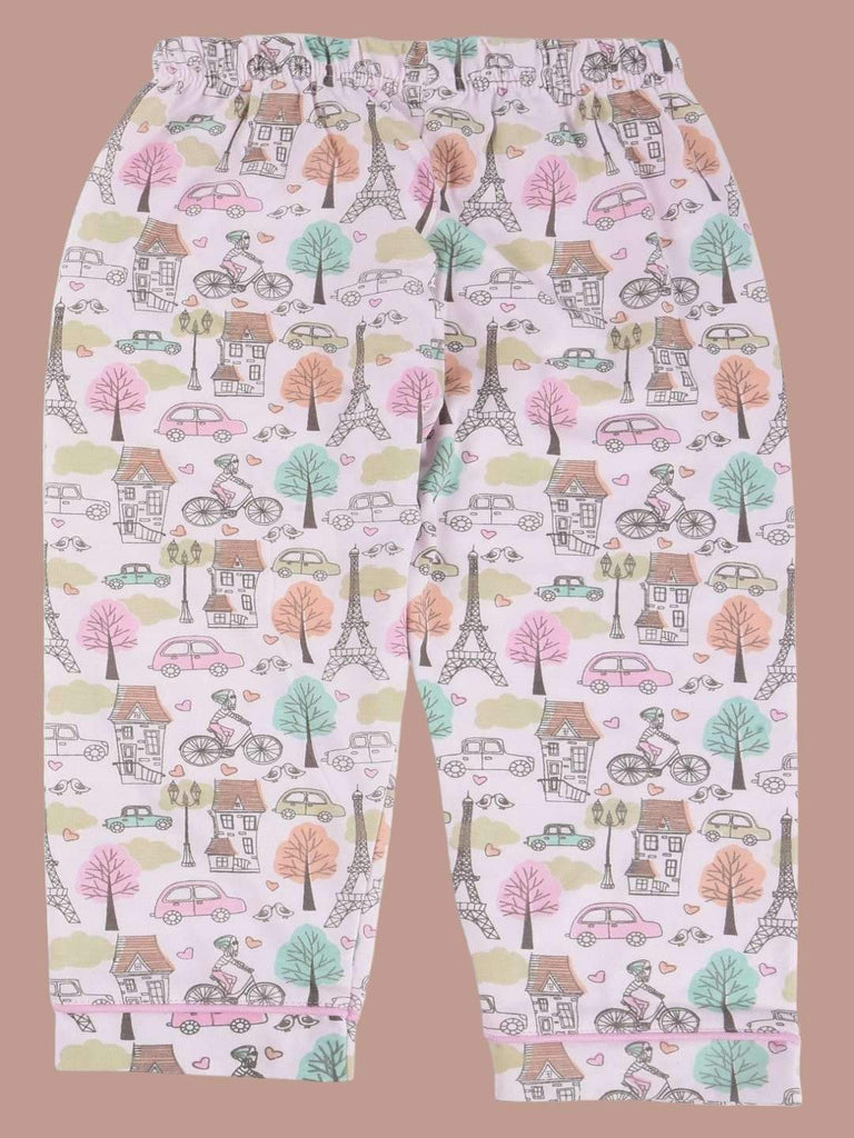 Full view of a girls' pajama set with printed design featuring Parisian landmarks, trees, bicycles, and cars in pastel colors.