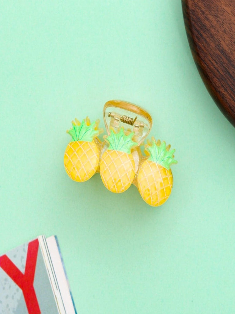 Creative view of the Tropical Pineapple Hair Claw Clip by Yellow Bee featuring three vibrant yellow pineapples with green tops