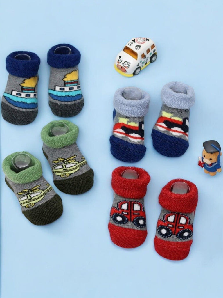 Assorted kids' transport-themed socks with various vehicle prints on a playful background.