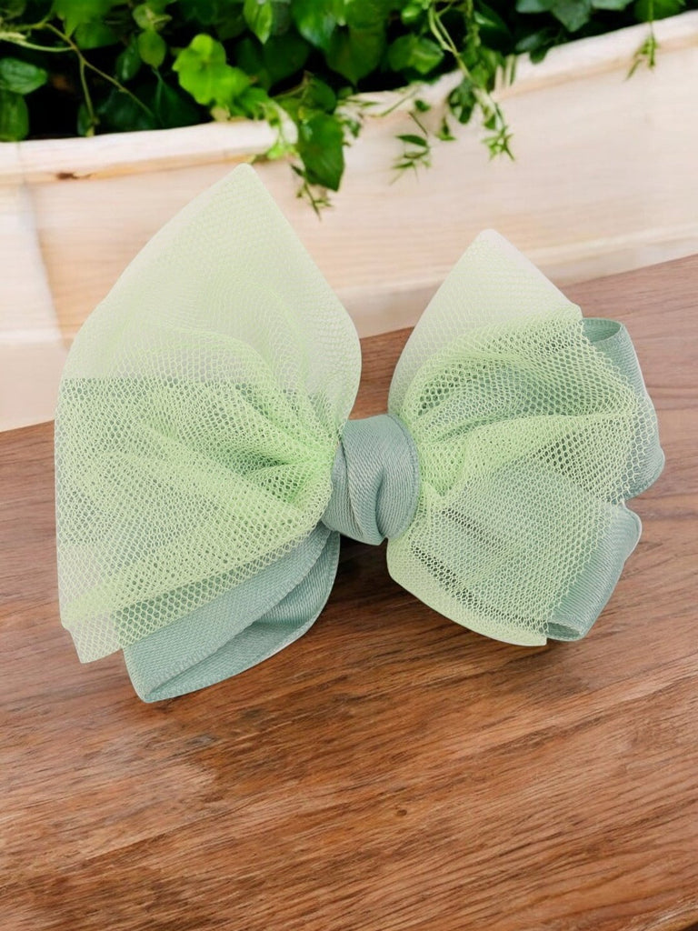 Creative view of the whimsical pastel green tulle hair bow showing the delicate net layers by Yellow Bee.