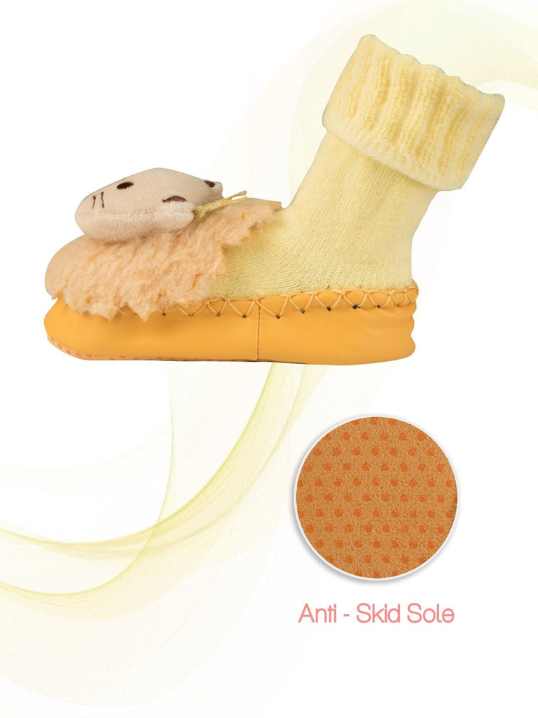 Side view infographic of yellow baby moccasin socks with lion design and anti-skid sole.